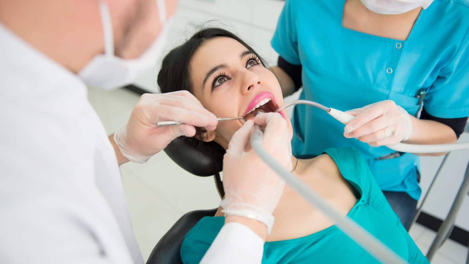Ragazza con maglia verde durante la pulizia dei denti